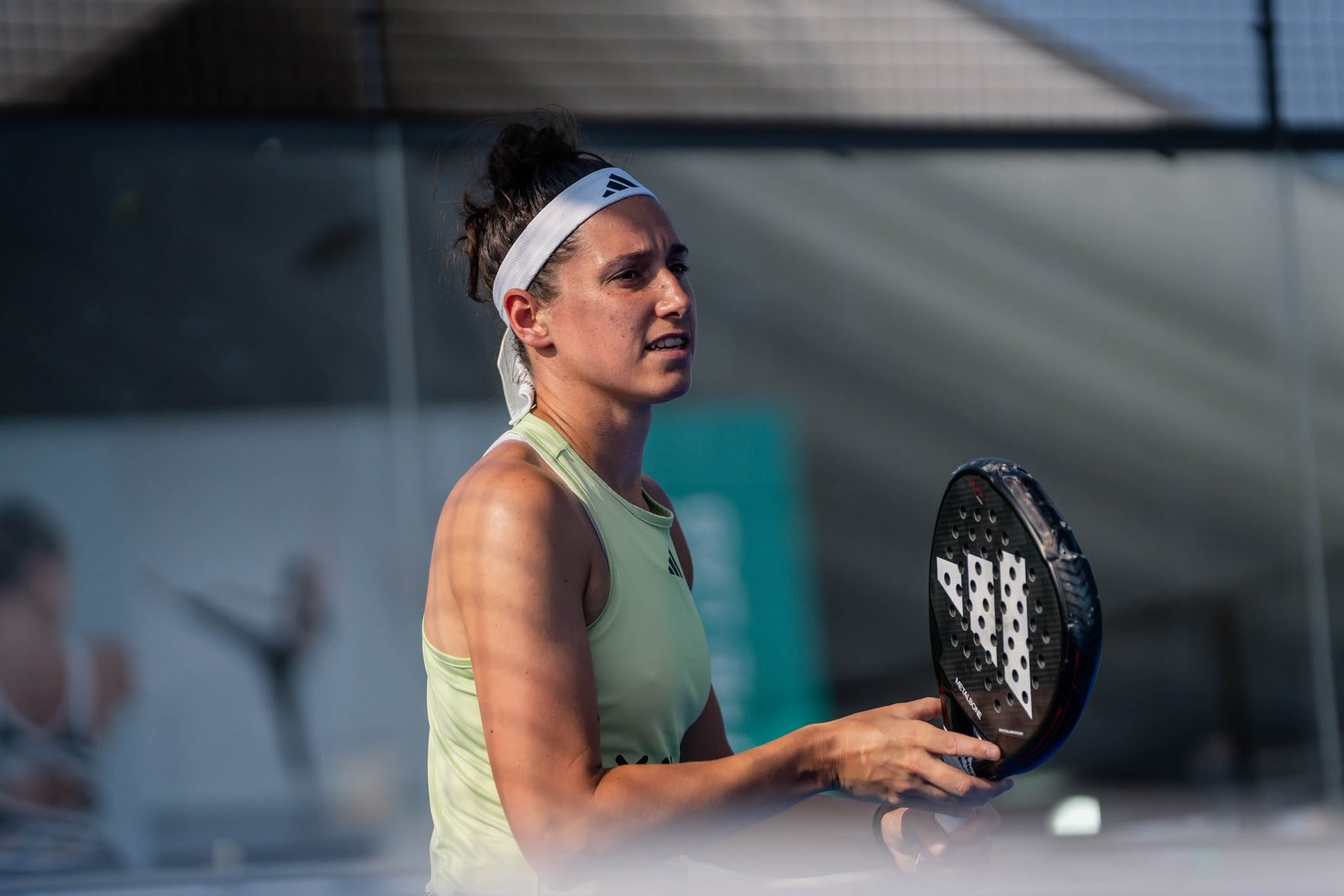 Padelspeelster met racket in de hand, geconcentreerd op het spel