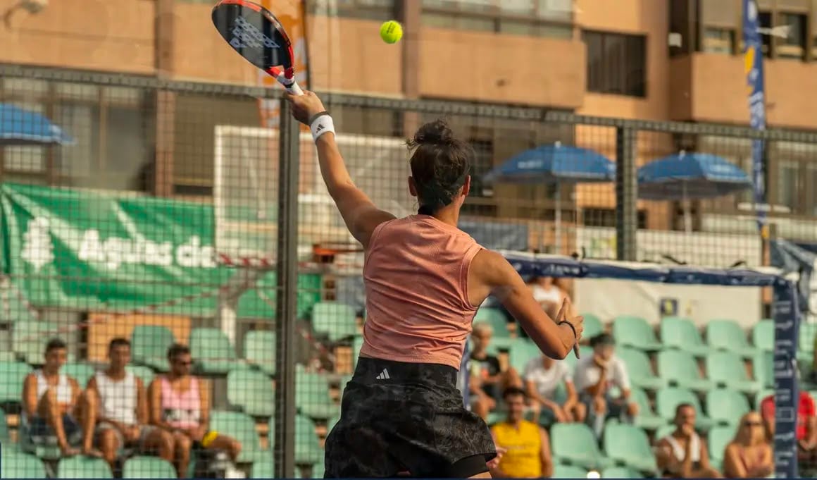 Padelspeelster slaat een volley voor een volle tribune